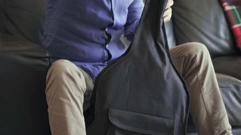 Senior man taking classical guitar out of bag Stock Footage 201360718