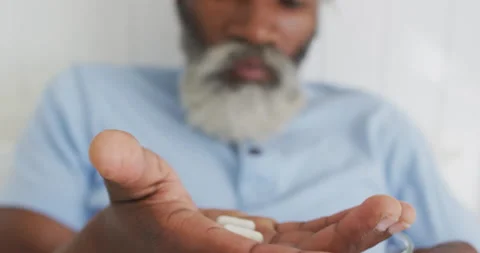 Senior man taking pills in bed at home Stock Footage 139747481