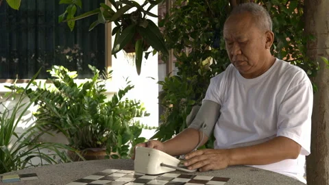 Senior man taking self-measurement of blood pressure Stock Footage 253147064