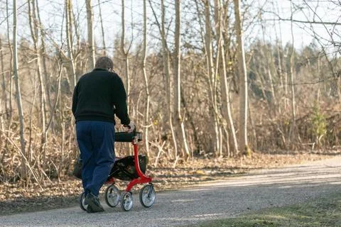 Senior man taking a walk with walker in the park. Stock Photos