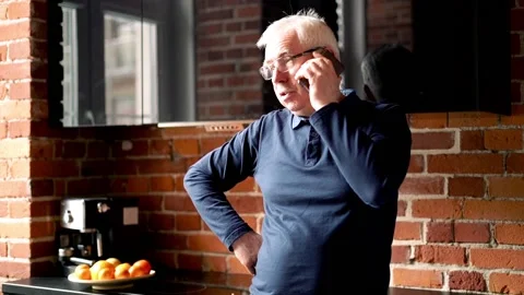 Senior man talking on cellphone in the kitchen Stock Footage 87621923