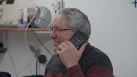 Senior man talking on phone inside tailoring workshop Stock Footage 331947887