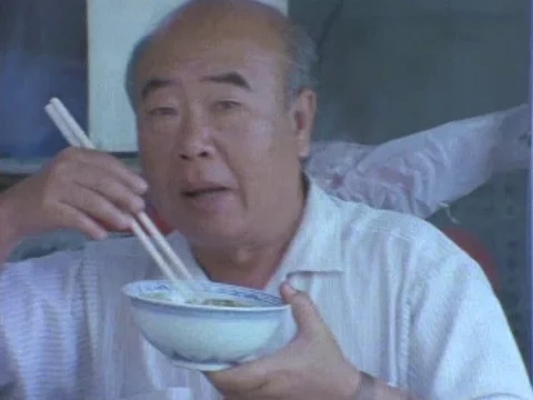 Senior man talking while having food with chopstick Stock Footage 79879264