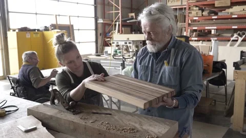 Senior man teaching apprentice in carpentry workshop Video stock 220467791