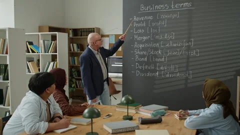 Senior Man Teaching Business Terms to Migrant Students Stock Footage 337481861