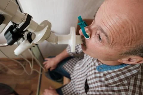 Senior man testing breathing function by spirometry Stock Photos