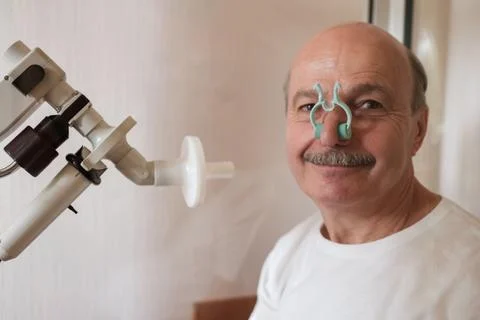 Senior man testing breathing function by spirometry Stock Photos