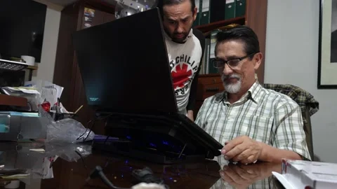 A senior man testing a stand for his Toshiba laptop with his children as Stock Footage 167370146