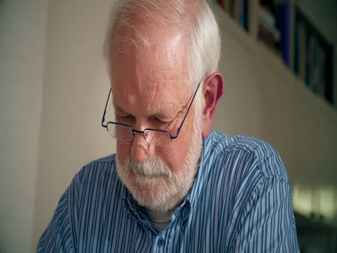 Senior man thinking about what he is reading Stock Footage 74398454