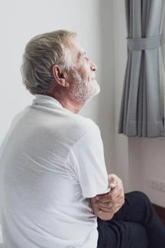 Senior man thinking or try to remember alone on bed in white room Stock-Fotos