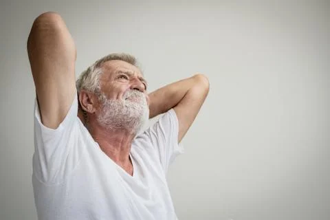 Senior man thinking or try to remember alone on bed in white room Stock-Fotos