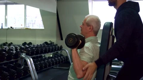 Senior man trains his shoulders with focused determination Video stock 311654953