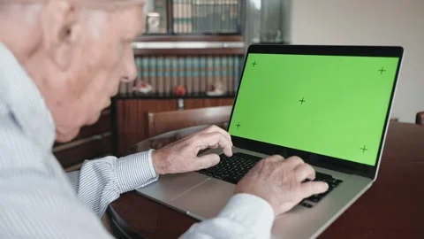 Senior man typing on computer keyboard with green screen chroma key Stock-Footage 181564544