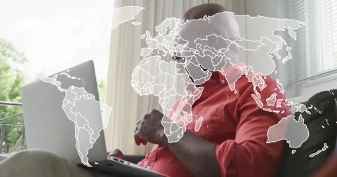 Senior man typing on laptop in tech demo, shifting transparent world map overlay Stock Footage 318688593
