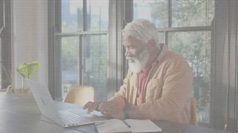 Senior man typing on laptop by windows, checking notes, starting animated work Stock Footage 333078380