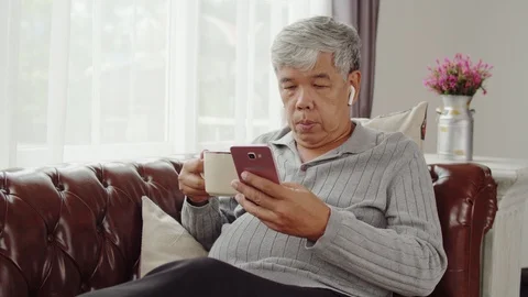 Senior man use wireless earphone listening music and talking telephone Stock Footage 118951465