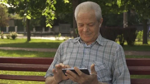 Senior man uses tablet on the bench Stock Footage 79617825