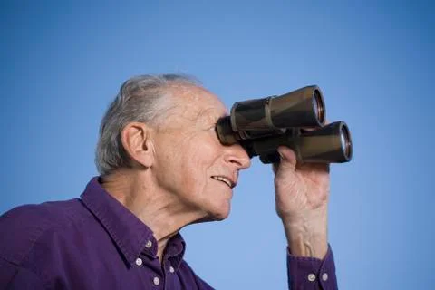 A senior man using binoculars Stock Photos