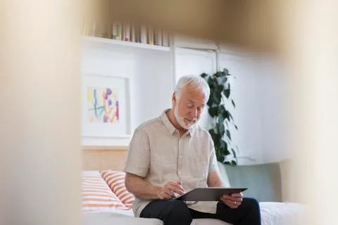 Senior man using digital tablet on bed Stock Photos