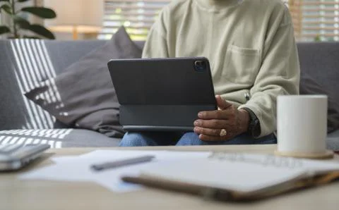 Senior man using digital tablet, reading online book or browsing internet w.. Stock Photos