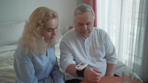 Senior man using home device for blood pressure measure with help and support of Video stock 278424062