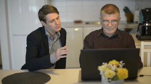 Senior man using laptop computer with younger man Stock Footage 68613258