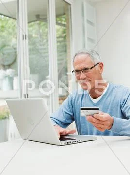Senior Man Using Laptop With Credit Card
