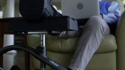 Senior man using a laptop at home with his broken leg propped up Stock Footage 83394535