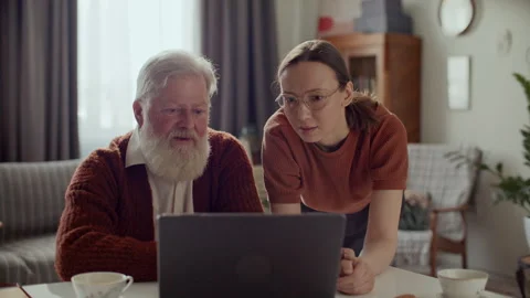 Senior Man Using Laptop at Home with Help from Young Daughter Stock Footage 305722677