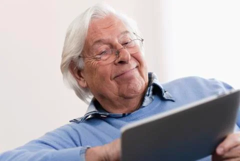 Senior man using laptop, smiling Stock Photos