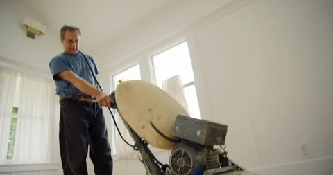 Senior man using a machine to sand a wooden floor. 스톡 동영상 88375579