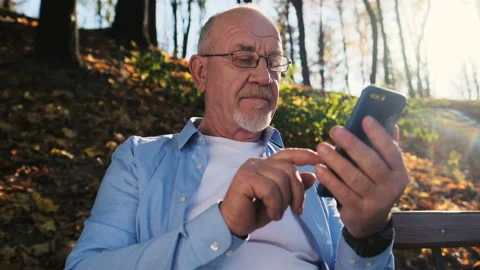 Senior man using mobile phone, holding smart phone, texting, surfing internet Stock Footage 97795142
