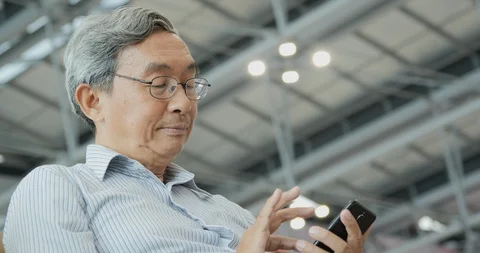 Senior man using mobile phone on the flight timetable. 스톡 동영상 116663603