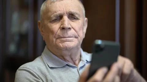 Senior man using a mobile phone, indoor lifestyle scene Stockbeeldmateriaal 346176395