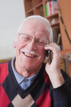 Senior man using mobile phone at home Stock Photos