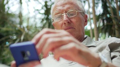 Senior Man Using Modern Mobile Phone Touchscreen, Scrolling And Reading News Stock Footage 92937550