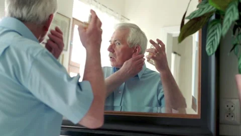 Senior man using perfume in front of the mirror Stock Footage 102914057