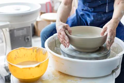 Senior man using pottery wheel in studio Stock Photos