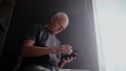 Senior Man Using Smartphone for Digital Banking and Mobile Payments at Home Stock Footage 337930489