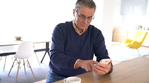 Senior man using smartphone at home Stock Footage 72138098