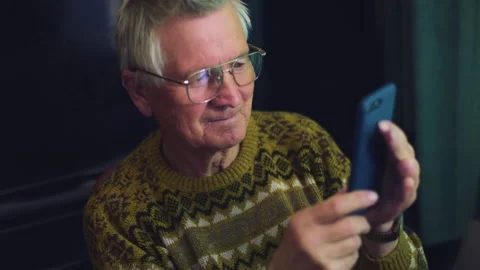 Senior man using a smartphone on the sofa at home Stock Footage 135038151