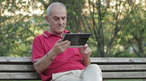Senior man using tablet computer in park Stock Footage 32496513