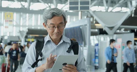 Senior man using tablet on the flight timetable background in airport. Stock Footage 116550944