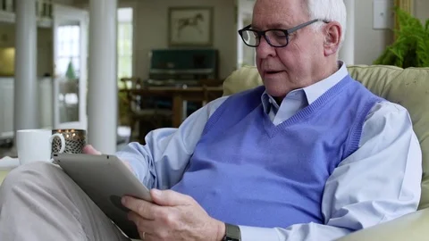 Senior man using a tablet at home 動画素材 83394478