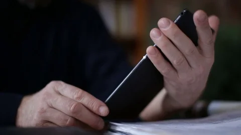 Senior man using tablet sitting on white couch in living room. Starting and Stock Footage 74737319