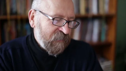 Senior man using tablet sitting on white couch in living room. Starting and Stock Footage 74739181