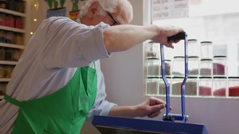 Senior man using a tee shirt printing machine Stock Footage 112004629