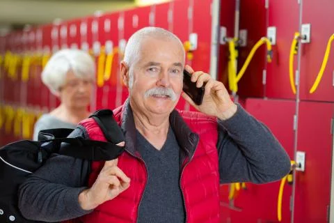 Senior man using telephone in locker room Stock Photos