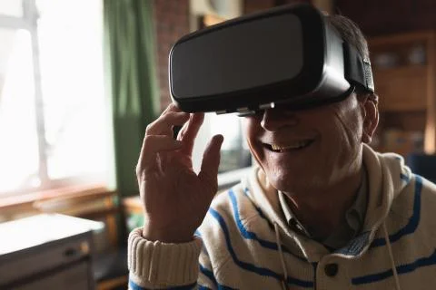 Senior man using virtual reality headset at home Fotos Stock