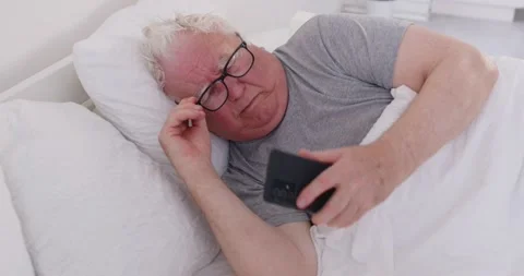 Senior Man Waking Up To A Phone Notification In Bed During The Morning Stock Footage 308665146